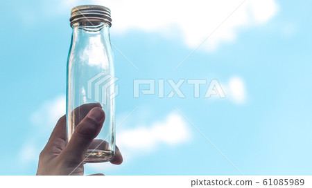 male Hand hold transparent glass bottle. empty bottle male Hand hold transparent glass bottle. empty bottle 61085989