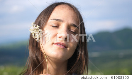 Young beautiful woman with closed eyes has relax in the field Young beautiful woman with closed eyes has relax in the field 61088500
