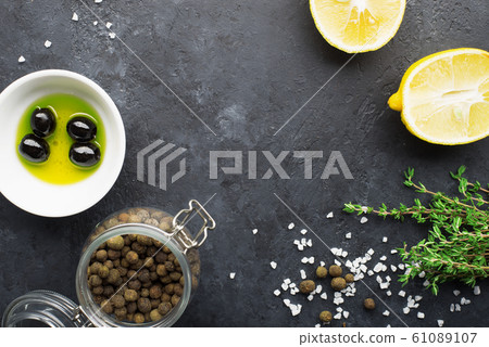 Black food frame background with fresh aromatic herbs and spices, copy space, top view. Allspice, thyme, lemon, olives olives on a dark background Black food frame background with fresh aromatic herbs and spices, copy space, top view. Allspice, thyme, lemon, olives olives on a dark background 61089107