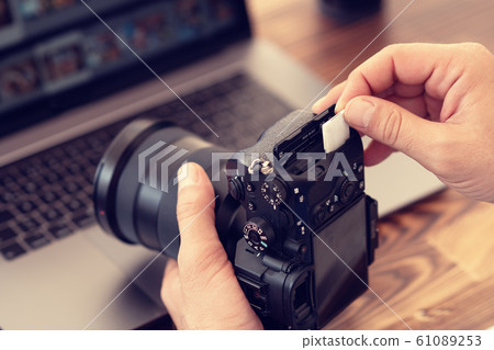 Photographer inserting or removing a memory card in professional camera Photographer inserting or removing a memory card in professional camera 61089253