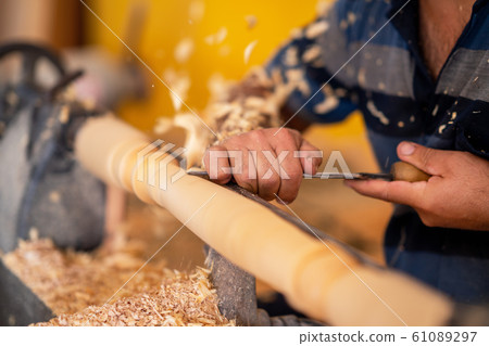 Carpenter working on wood to carving and shaping Carpenter working on wood to carving and shaping 61089297