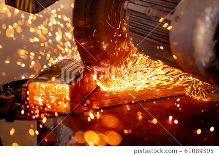 Cutting industrial metal with grinder. Sparks while grinding iron 61089305