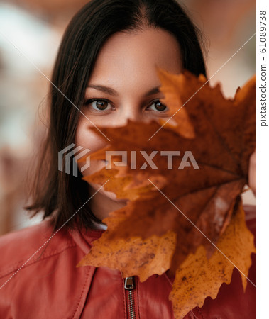 beautiful woman enjoying in park or forest and looking fascinating with leaves on hand 61089738