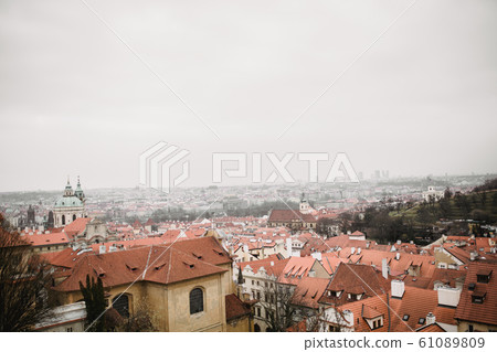 Panorama of Prague with red roofs and Church. City view of Praha old city. Rustic grey colors toning. Panorama of Prague with red roofs and Church. City view of Praha old city. Rustic grey colors toning. 61089809