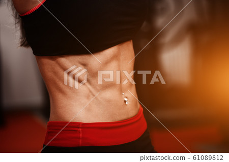 Sporty girl in gym show abs. woman in tonus Sporty girl in gym show abs. woman in tonus 61089812