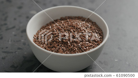 flaxseed in white bowl on terrazzo countertop with copy space 61090500