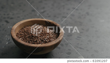 flaxseed in olive bowl on terrazzo countertop with copy space 61091207