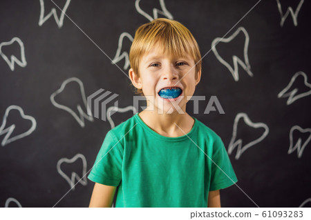Six-year old boy shows myofunctional trainer. Helps equalize the growing teeth and correct bite 61093283
