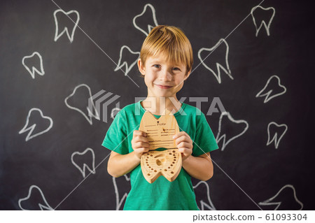 A boy, 6 years old, holds a box for milk teeth. Change of teeth A boy, 6 years old, holds a box for milk teeth. Change of teeth 61093304