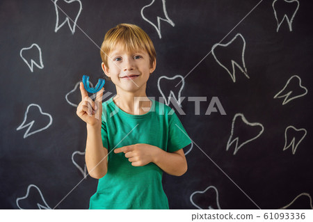 Six-year old boy shows myofunctional trainer. Helps equalize the growing teeth and correct bite Six-year old boy shows myofunctional trainer. Helps equalize the growing teeth and correct bite 61093336