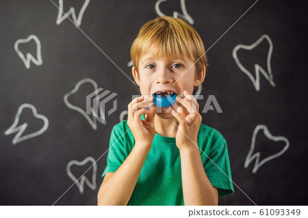 Six-year old boy shows myofunctional trainer. Helps equalize the growing teeth and correct bite Six-year old boy shows myofunctional trainer. Helps equalize the growing teeth and correct bite 61093349