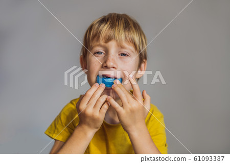 Six-year old boy shows myofunctional trainer. Helps equalize the growing teeth and correct bite 61093387