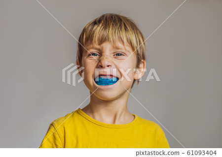 Six-year old boy shows myofunctional trainer. Helps equalize the growing teeth and correct bite Six-year old boy shows myofunctional trainer. Helps equalize the growing teeth and correct bite 61093404
