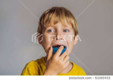 Six-year old boy shows myofunctional trainer. Helps equalize the growing teeth and correct bite Six-year old boy shows myofunctional trainer. Helps equalize the growing teeth and correct bite 61093433