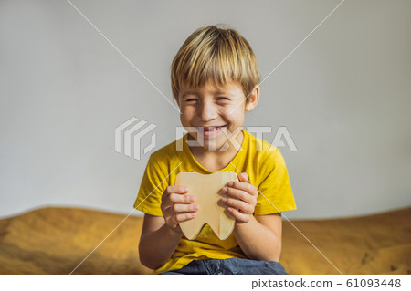 A boy, 6 years old, holds a box for milk teeth. Change of teeth 61093448