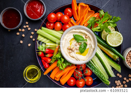 Hummus platter with assorted snacks. 61093521