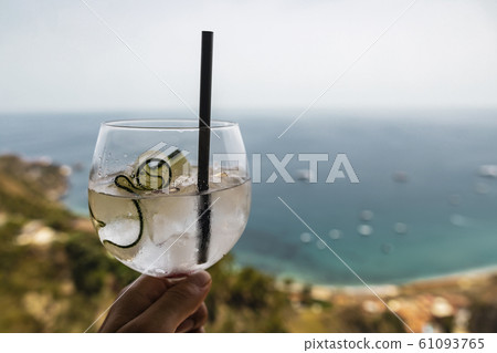 Cucumber cocktail drink in front of tropical sea 61093765