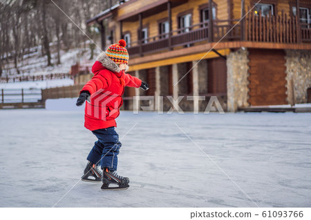 Boy ice skating for the first time Boy ice skating for the first time 61093766