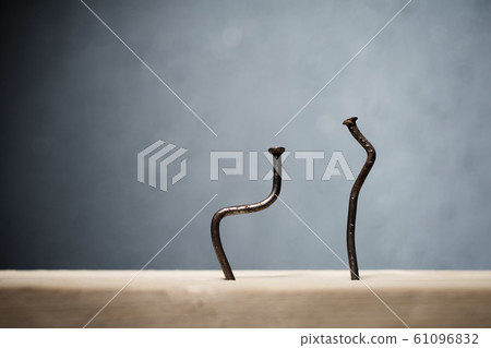 Two bent nails driven into a board. Concept stoop, Two bent nails driven into a board. Concept stoop, 61096832
