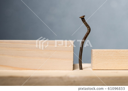 Wooden blocks and bent nail. Office worker 61096833