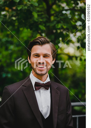Close-up portrait of handsome young bridegroom with elegant stylish haircut 61096982
