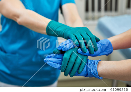 surgeons joining hands together after work for rescue patient in operation room at hospital, emergency case, surgery, medical technology, disease treatment concept surgeons joining hands together after work for rescue patient in operation room at hospital, emergency case, surgery, medical technology, disease treatment concept 61099216