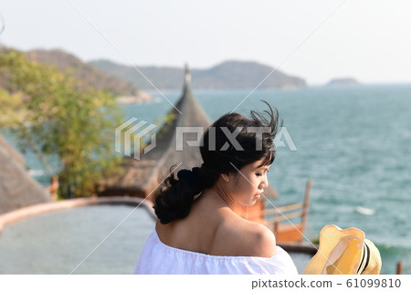 突出在夏天亞洲海岸線的海運背景的一個少婦 突出在夏天亞洲海岸線的海運背景的一個少婦 61099810