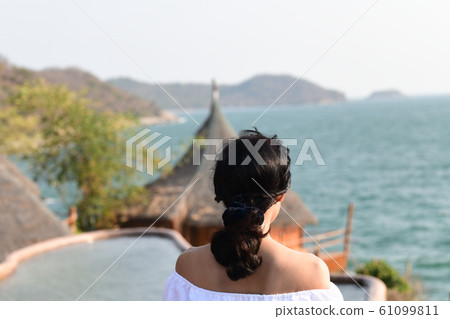 One young woman standing out on the sea background on the summer Asian coastline One young woman standing out on the sea background on the summer Asian coastline 61099811