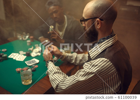 Poker players place money bets on gaming table 61100039