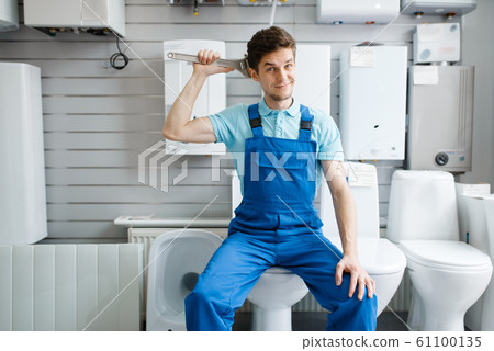 Plumber sitting on toilet in plumbering store 61100135