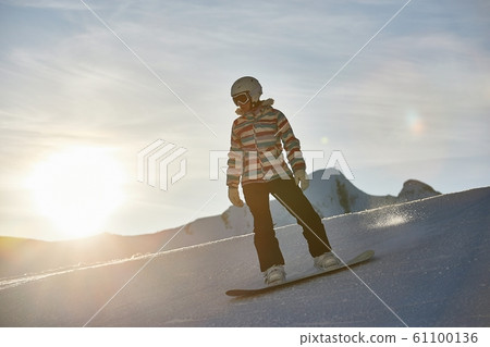 Snowboarder in sun flare, water drops on lens Snowboarder in sun flare, water drops on lens 61100136