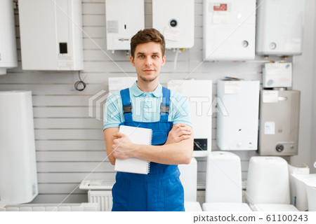 Plumber at showcase with boilers, plumbering store Plumber at showcase with boilers, plumbering store 61100243