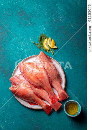 Fresh red sea bass on blue background. Top view, copy space 61103046