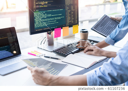 Young startup Programmers Sitting At Desks Working 61107236