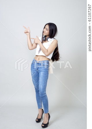 Asian woman wearing headphones dancing active Asian woman wearing headphones dancing active 61107267