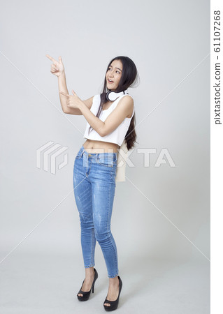 Asian woman wearing headphones dancing active 61107268