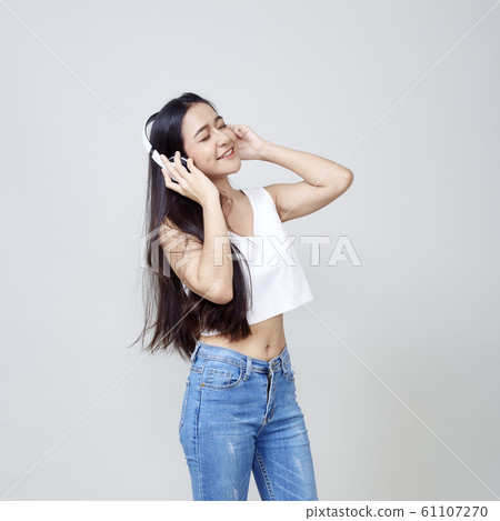 Asian woman wearing headphones dancing active Asian woman wearing headphones dancing active 61107270