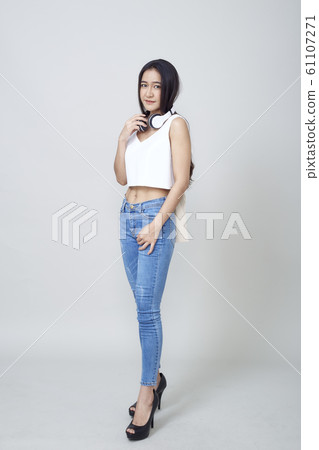 Asian woman wearing headphones dancing active Asian woman wearing headphones dancing active 61107271