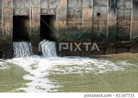 Dirty water flows from city, waste water flows polluting water	 61107735