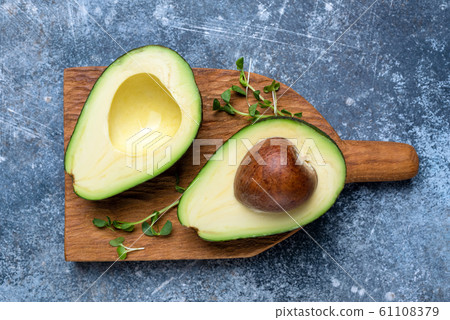 Halved avocado on a chopping board Halved avocado on a chopping board 61108379