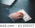 businessman hand money on black desk in office 61109207
