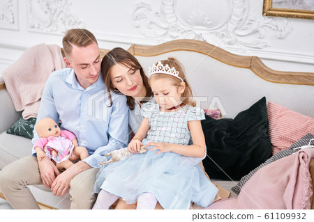 Loving family Mom and dad, little daughter . Parents and baby child having fun. Merry Christmas and Happy New Year. Cheerful pretty people. Loving family Mom and dad, little daughter . Parents and baby child having fun. Merry Christmas and Happy New Year. Cheerful pretty people. 61109932