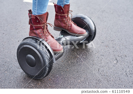 Close up of woman using hoverboard on asphalt 61110549