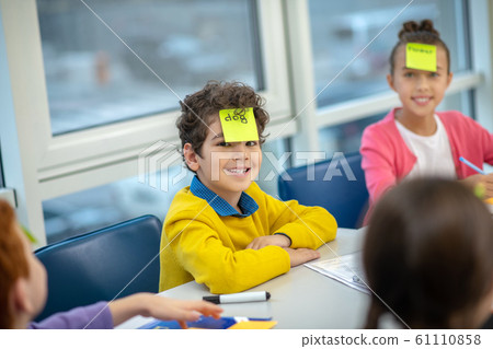 Schoolboy smiling trying to guess the English word Schoolboy smiling trying to guess the English word 61110858