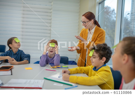 Teacher helping school children playing words game 61110866