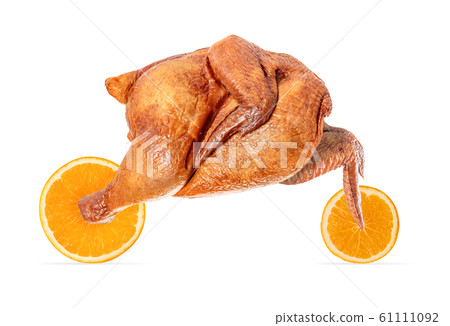 Appetizing grilled chicken with browned skin rides on orange slices like a racing motorcycle. Concept: food delivery, fast delivery. Appetizing grilled chicken with browned skin rides on orange slices like a racing motorcycle. Concept: food delivery, fast delivery. 61111092