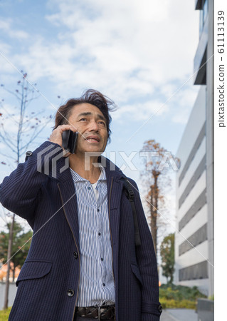 Businessman talking on a smartphone Businessman talking on a smartphone 61113139