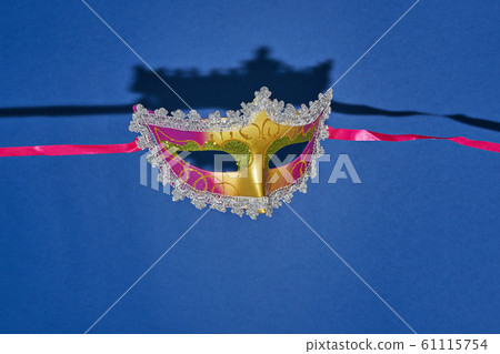 Mardi Gras masquerade mask on blue background with 61115754