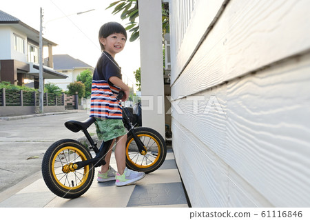 happy asian cute boy riding balance bike on street happy asian cute boy riding balance bike on street 61116846