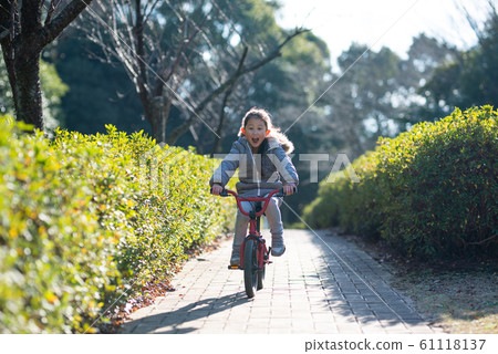 A girl riding a bicycle 61118137